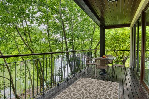 a screened porch with a table and chairs on it at Tisza Balneum Hotel in Tiszafüred