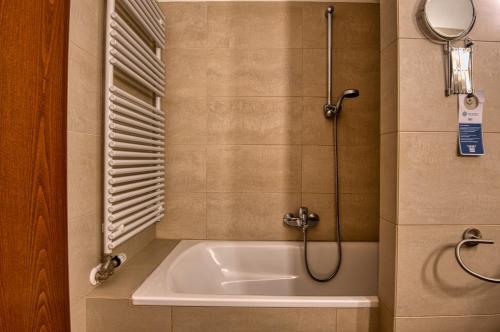 a bathroom with a bath tub with a shower at Tisza Balneum Hotel in Tiszafüred
