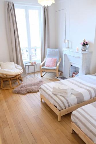 - un salon avec deux lits et une cheminée dans l'établissement Aux pieds du Métro ligne 12, à Aubervilliers