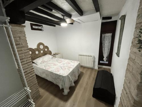 ein Schlafzimmer mit einem Bett und einer Ziegelwand in der Unterkunft La Casita in Arenas de San Pedro