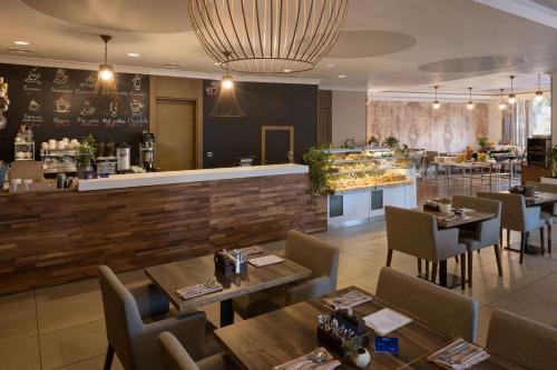 a restaurant with wooden tables and chairs and a bar at Radisson Blu Hotel, Kyiv Podil City Centre in Kyiv