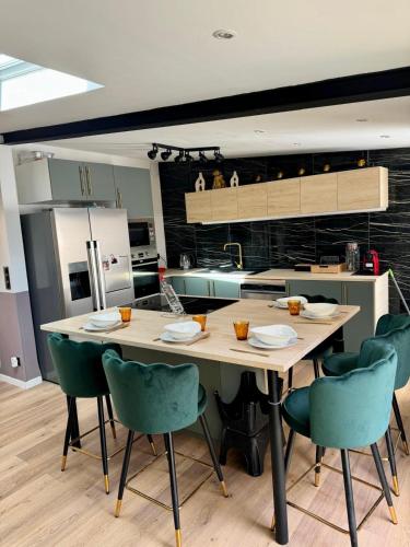 une cuisine avec une table et des chaises dans une cuisine dans l'établissement Cosy House Near DisneyLand Paris, à Roissy-en-Brie