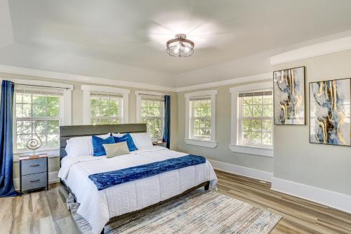 a bedroom with a bed with blue pillows and windows at 3 Mi to Dtwn Memphis Family Home in Memphis