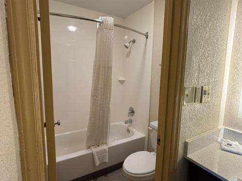 a bathroom with a tub and a toilet and a shower at Studio 6 Suites Charlotte, NC Northlake in Charlotte