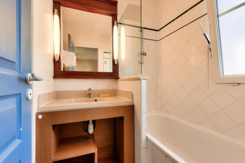 une salle de bain avec un lavabo, une baignoire et un miroir dans l'établissement Les Maisons de Lacanau les Pins - maeva Home - Maisons 3 pièces 6 personnes - Prestige MAE-4591, à Lacanau