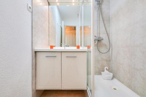 une salle de bain blanche avec un lavabo et une douche dans l'établissement Résidence le Hameau des Issambres - maeva Home - Appartement avec jardin 2 pièces 4 personnes - Prestige - super Home MAE-4621, aux Issambres