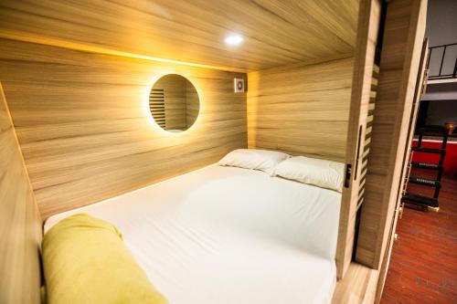 a small bed in a room with a wooden wall at Hotel La Sin Ventura in Antigua Guatemala