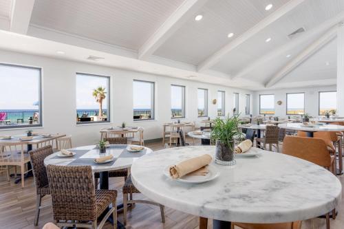 a dining room with tables and chairs and windows at SpringHill Suites by Marriott Navarre Beach in Navarre