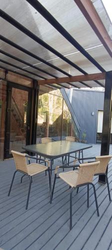 a patio with a table and chairs on a deck at Inspiramide Pucon in Pucón