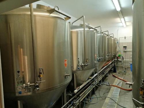 a row of stainless steel tanks in a brewery at Penzion Eška s Pivovarem MJ in Jince