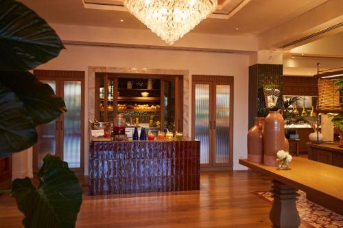 um bar num restaurante com um lustre em The St. Regis Mardavall Mallorca Resort em Portals Nous