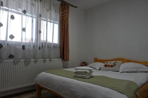 una camera da letto con un letto con asciugamani sopra di Pensiunea Tiplea a Ocna Şugatag