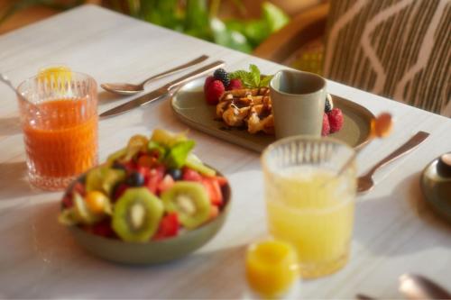 uma mesa com um prato de comida e um prato de fruta em The St. Regis Mardavall Mallorca Resort em Portals Nous