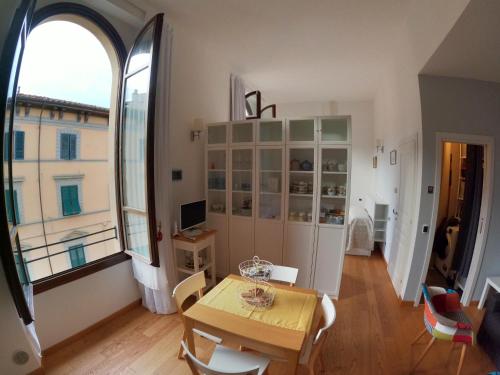 a dining room with a table and a large window at Five Roses Bed & Breakfast in Pisa