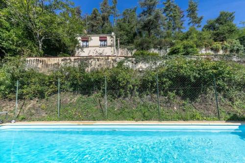 une maison au sommet d'une colline avec une piscine dans l'établissement Le Clos de la Cisse - Maison semi-troglodyte, à Nazelles-Négron