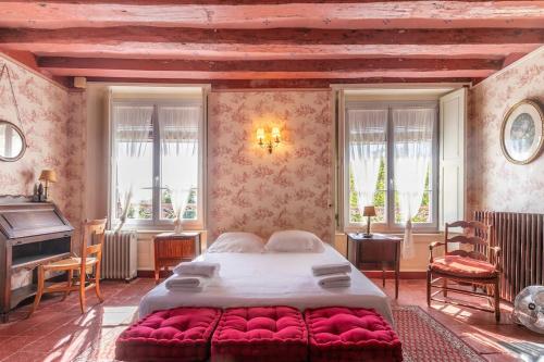 a bedroom with a large bed and a piano at Le Clos de la Cisse - Maison semi-troglodyte in Nazelles