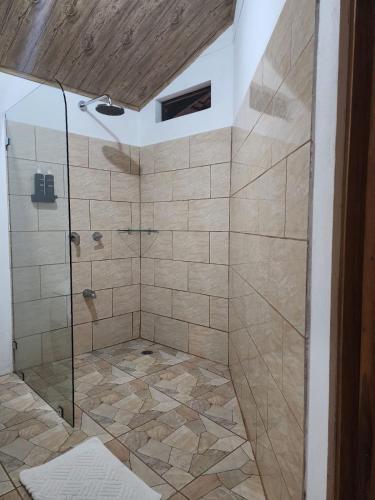 a shower with a glass door in a bathroom at Casa THIREMA Tortuguero in Tortuguero