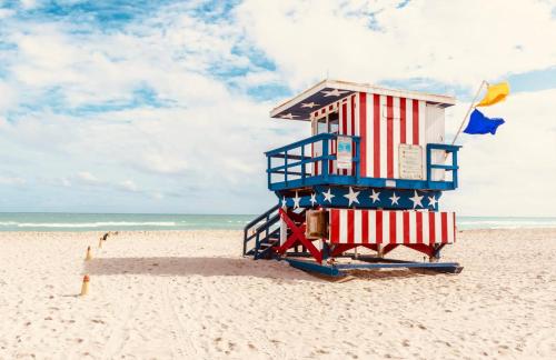 una torre salvavidas en una playa con bandera americana en 2 Bedroom Apartment 3 Minute Walk to South Beach & Ocean Drive, en Miami Beach