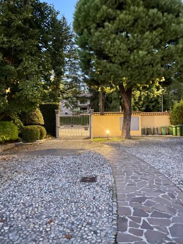 a stone walkway with a tree in the background at Interno 13 - Coffee, Wifi & Mxp in Somma Lombardo