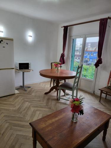 un salon avec une table et une cuisine avec une fenêtre dans l'établissement Spacieux appartement de 70m2 au coeur de la Patte d'Oie d'Herblay sur Seine, à Montigny-lès-Cormeilles