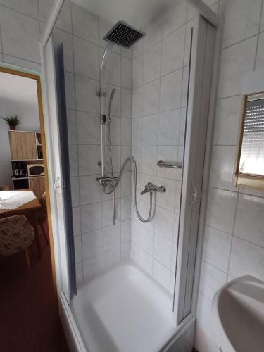 a shower with a glass door next to a sink at Pension Glück Auf in Brand-Erbisdorf