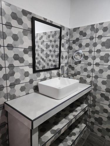 a bathroom with a white sink and a mirror at Casa THIREMA Tortuguero in Tortuguero