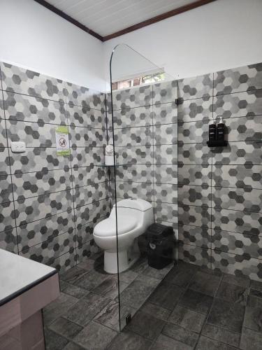 a bathroom with a toilet and a shower at Casa THIREMA Tortuguero in Tortuguero