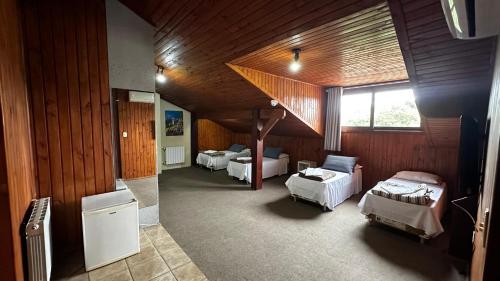a room with three beds and a staircase in it at Pousada Canela Garden in Canela