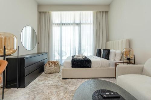a bedroom with a large bed and a mirror at Nasma Luxury Stays - Azizi Riviera 6 Cozy Studio with Burj Khalifa View in Dubai