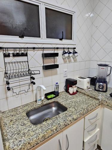 a kitchen with a sink and a counter top at Edifício Belluno in Ribeirão Preto