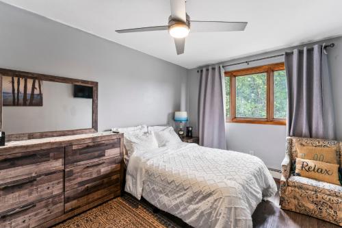 a bedroom with a bed with a dresser and a mirror at Quiet And Comfortable Deluxe in Anchorage