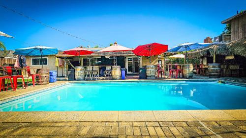 a large blue swimming pool with umbrellas and tables at Tropical Paradise in Fresno