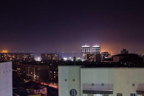 Blick auf eine nächtliche Stadt mit Lichtern in der Unterkunft Студия in Bischkek