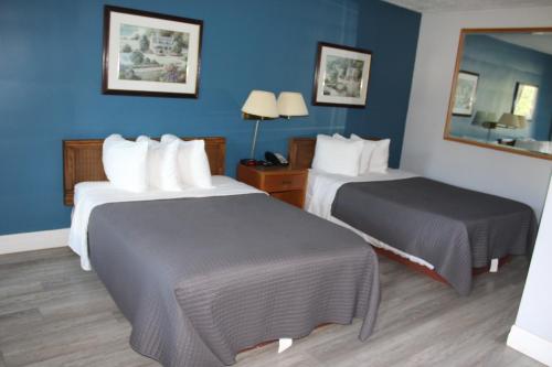 two beds in a hotel room with blue walls at Bancroft Inn & Suites in Bancroft