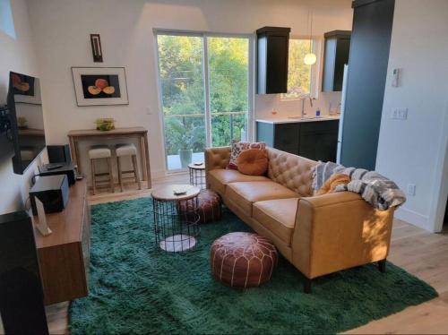 a living room with a brown couch and a green rug at The Loft in Salem