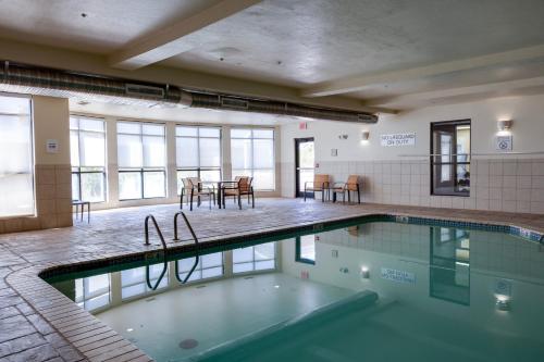 a swimming pool in a room with a table and chairs at Courtyard by Marriott Oklahoma City North/Quail Springs in Oklahoma City