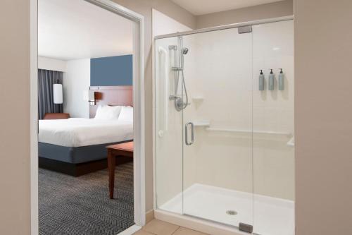 a bathroom with a shower in a hotel room at Courtyard by Marriott Oklahoma City North/Quail Springs in The Village