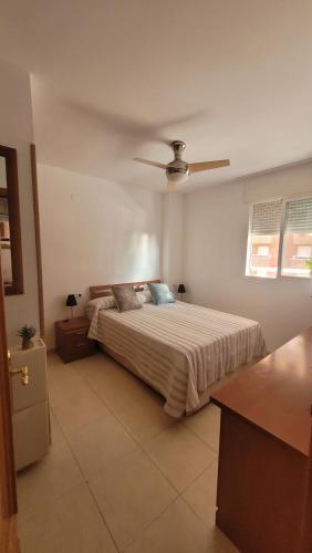 Un dormitorio con una cama y un ventilador de techo. en Mediterráneo Gourmet Stays, en Oropesa del Mar