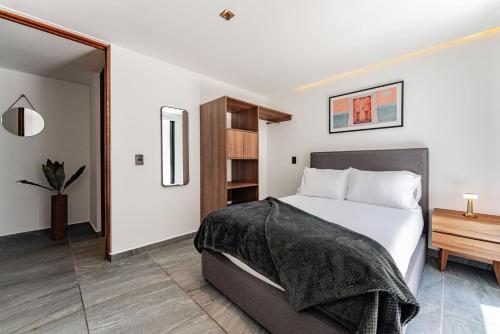 a bedroom with a large bed and a wooden cabinet at Santa Ma la Ribera Apartments by VH in Mexico City