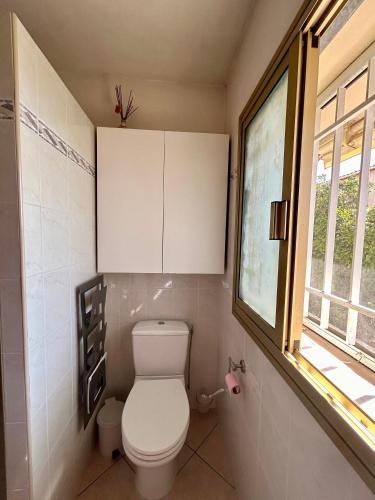 une salle de bain avec des toilettes blanches et une fenêtre dans l'établissement Les Ondes - Terrasse RdC Villa Calme Parking Proche Plage, à Antibes
