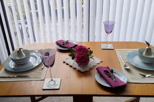 a wooden table with plates and wine glasses on it at Ludlow Mews Town House with Free parking in Ludlow