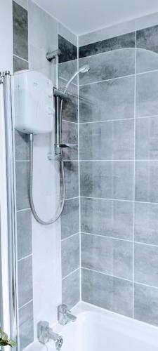 a shower with a glass door in a bathroom at Ludlow Mews Town House with Free parking in Ludlow