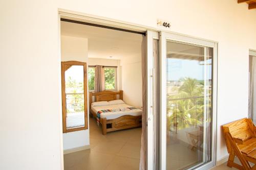 a bedroom with a view of a bed and a balcony at Hotel Caribe Coveñas in Coveñas