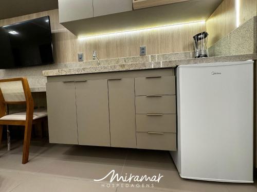 a kitchen with a sink and a refrigerator at Beach Haus in Tambaú