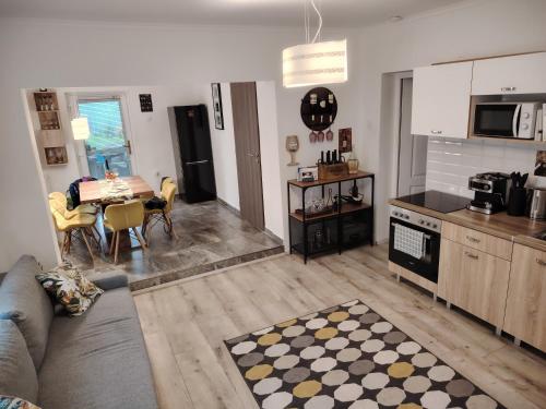 ein Wohnzimmer mit einem Sofa und eine Küche mit einem Tisch in der Unterkunft Furmint Home in Szegi