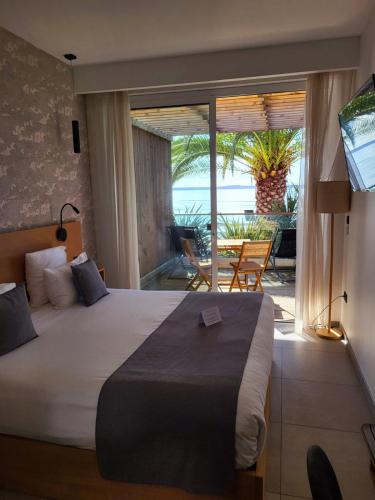 une chambre avec un lit et une vue sur l'océan dans l'établissement Hôtel L'Albatros, à Saint-Trojan-les-Bains