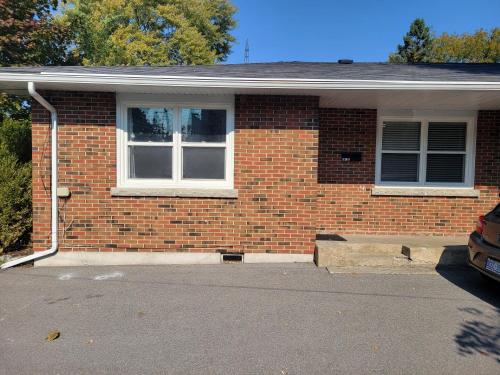a brick house with a window and a driveway at Comfy Rooms Stay - Unit 1 in Kingston