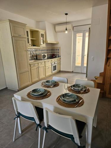 - une cuisine avec une table blanche avec des assiettes et de la vaisselle dans l'établissement La Maison d'Alex, à Arles