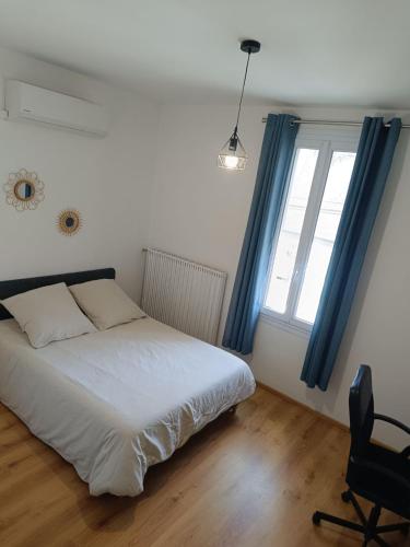 une chambre avec un lit, une chaise et une fenêtre dans l'établissement La Maison d'Alex, à Arles