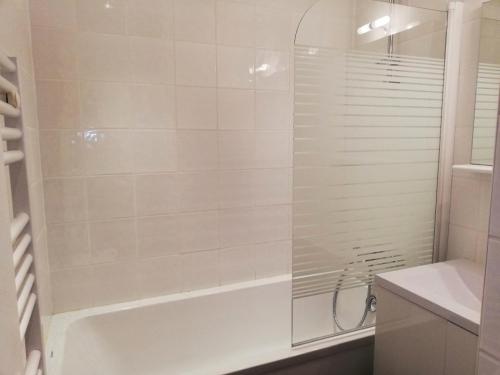 une salle de bain blanche avec une baignoire et une douche dans l'établissement Résidence Les Gentianes - Résidence LES GENTIANES N°F18 MAE-4741, à La Plagne Tarentaise